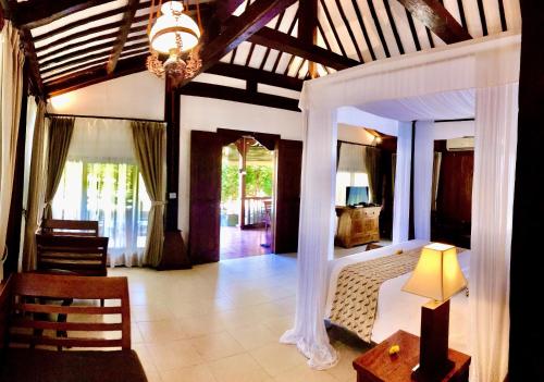 een slaapkamer met een bed en een kroonluchter bij Villa Berawa in Canggu