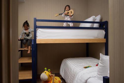 two children sitting on top of bunk beds at Eleven Hotel Bangkok Sukhumvit 11 in Bangkok
