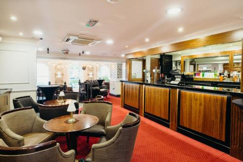 a restaurant with tables and chairs and a bar at Crown Spa Hotel Scarborough by Compass Hospitality in Scarborough