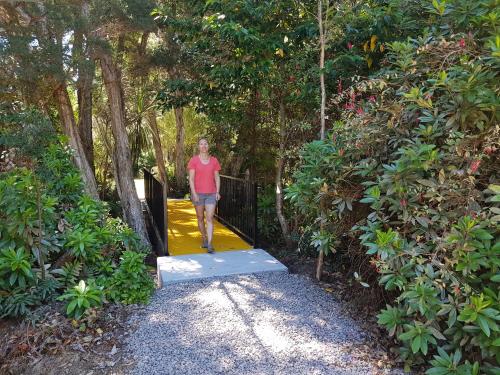 a woman walking through a gate on a walkway at Strahan Retreat Holiday Park in Strahan