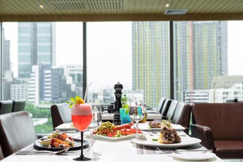 a table with plates of food and wine glasses at Sivatel Bangkok Hotel in Bangkok