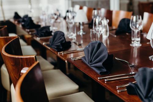 a long wooden table with napkins on top of it at Crown Spa Hotel Scarborough by Compass Hospitality in Scarborough