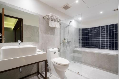 a bathroom with a toilet and a sink and a shower at True Siam Phayathai Hotel in Bangkok