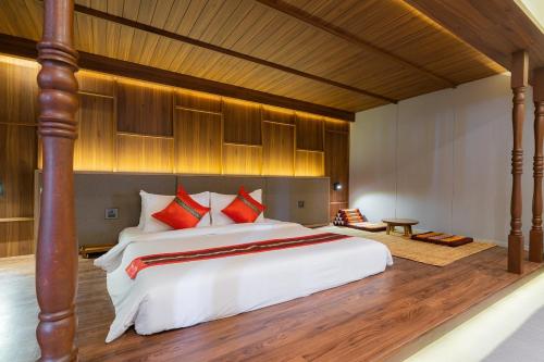 a bedroom with a large bed with red pillows at True Siam Phayathai Hotel in Bangkok