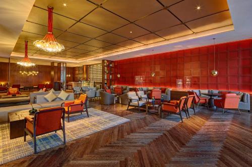 a lobby with tables and chairs and a bar at Pullman Huizhou Kaisa in Huizhou