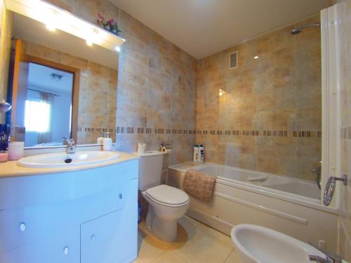 ein Badezimmer mit einem Waschbecken, einem WC und einer Badewanne in der Unterkunft Frontal en primera linea Vistamar 3 in Oropesa del Mar