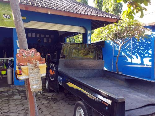 a blue truck parked in front of a building at Aqua Dive Paradise in Tulamben