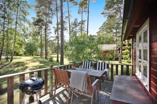 a deck with a grill and a table and chairs at Ljugarn Semesterby in Ljugarn