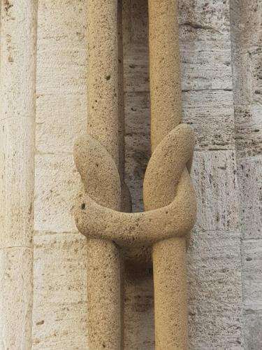 a stone structure on the side of a building at Palazzetto del Pittore in San Quirico d'Orcia in San Quirico dʼOrcia
