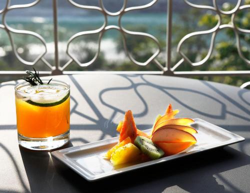 a plate of fruit and a drink on a table at Taj Rishikesh Resort & Spa Uttarakhand in Rishīkesh