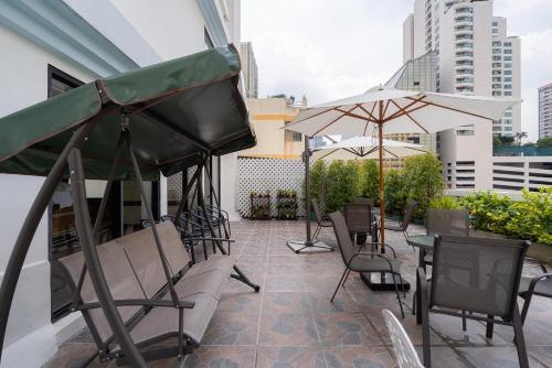 a patio with chairs and tables and umbrellas on a building at True Siam Phayathai Hotel in Bangkok