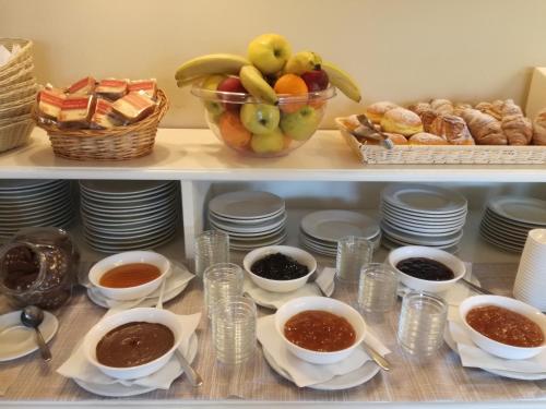 a shelf with bowls of food and a bowl of fruit at Hotel Punta Moros in Tertenìa