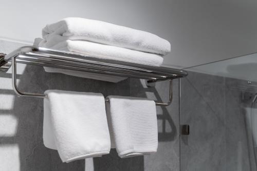 a group of towels on a towel rack in a bathroom at True Siam Phayathai Hotel in Bangkok