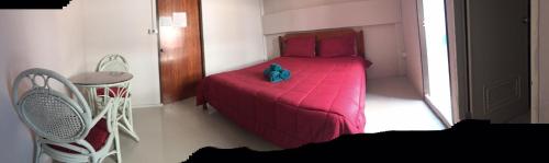 a small bedroom with a red bed with a stuffed animal on it at SMILE HOME GUESTHOUSE in Rayong