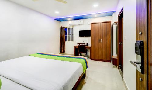 a hotel room with a bed and a desk at Ring View Hotels - Hebbal in Bengaluru