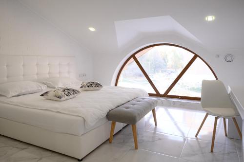 białe łóżko w pokoju z dużym oknem w obiekcie Patio di Fiori w mieście Łuck