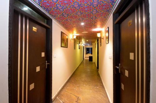 a hallway with a colorful ceiling and a hallway with doors at Hotel Surya Garh in Jaipur