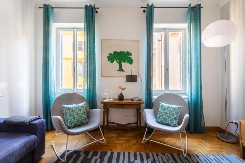 un soggiorno con 2 sedie e un divano blu di ROMAC Condotti with 3 bedrooms near the Spanish Steps a Roma