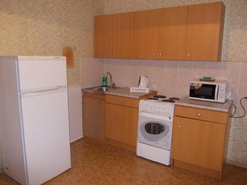 モスクワにあるApartment On Gerasima Kurinaのキッチン(白い冷蔵庫、電子レンジ付)