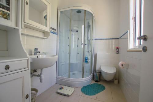 een badkamer met een douche, een wastafel en een toilet bij Villa Fig Tree in Protaras