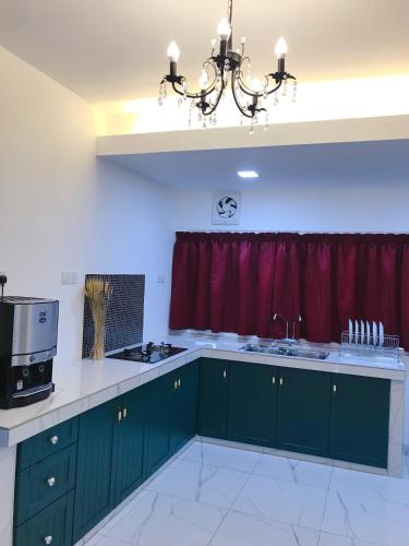 a kitchen with green cabinets and a red curtain at Botanic Gardens 26- 5-bedroom Near AEON Bukit Tinggi in Klang