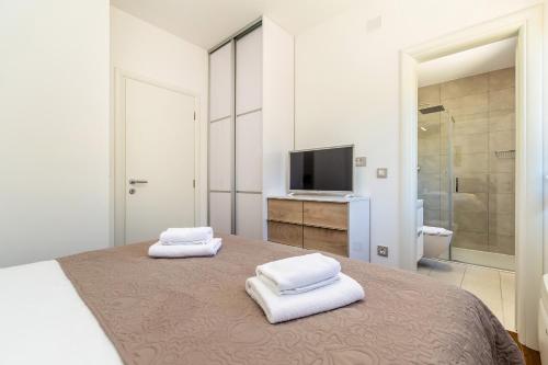 a bedroom with a bed with two white towels at Villa Insula Aurea No.1 in Linardići