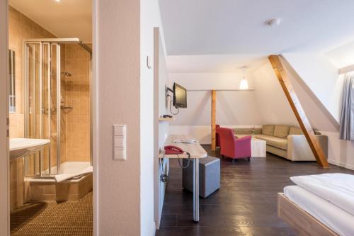 コンスタンツにあるLandhotel Traubeのバスルームとリビングルームが備わる客室です。