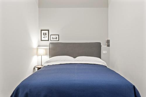- une chambre avec un lit et une couverture bleue dans l'établissement Piazza Maggiore White Apartment, à Bologne