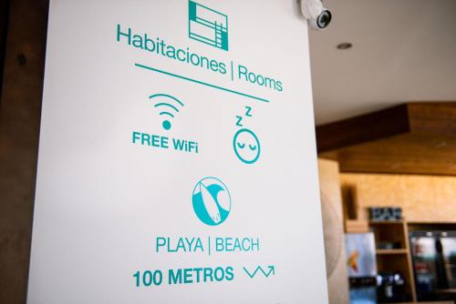 a sign on a wall in a room at TAKE SURF Hostel Conil in Conil de la Frontera