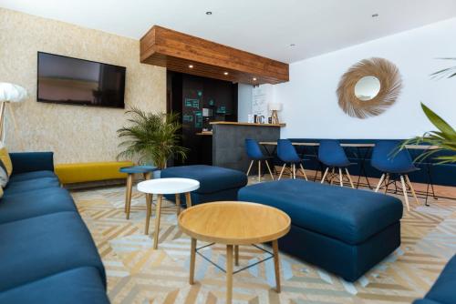 una sala de estar con sofás azules y un bar en TAKE SURF Hostel Conil en Conil de la Frontera