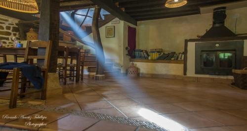Lavín的住宿－Albergue De Soba，客房设有壁炉、桌子和椅子。