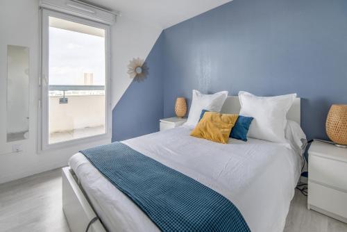 a blue bedroom with a bed and a window at Bel appartement de 2 chambres à 40 min de Paris in Evry-Courcouronnes