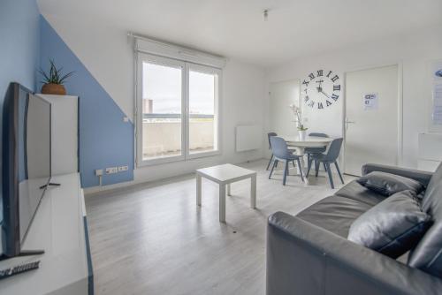 un salon avec un canapé et une table dans l'établissement Bel appartement de 2 chambres à 40 min de Paris, Évry-Courcouronnes
