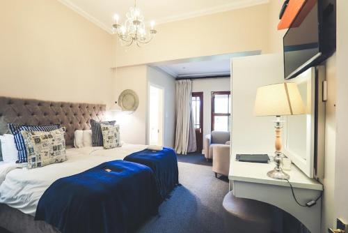 um quarto de hotel com uma cama com duas almofadas azuis em The Nottingham Road Hotel em Nottingham Road