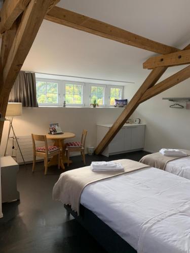 a room with two beds and a table and chairs at Relais du Simplon in Conthey