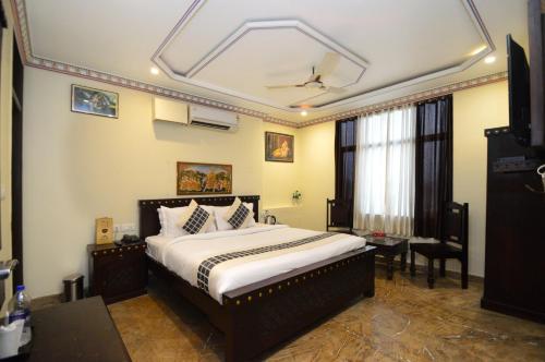 a bedroom with a bed and a television in it at Hotel Surya Garh in Jaipur
