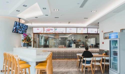 a person sitting at a table in a restaurant at Westlake Service Apartment in Hangzhou