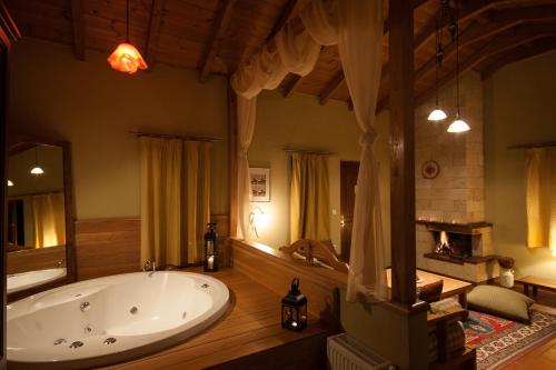 a large bathroom with a tub and a fireplace at Amadryades Boutique Hotel in Alatopetra
