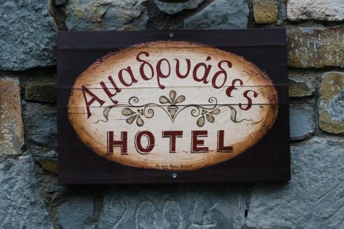 a sign for a hotel on a brick wall at Amadryades Boutique Hotel in Alatopertra