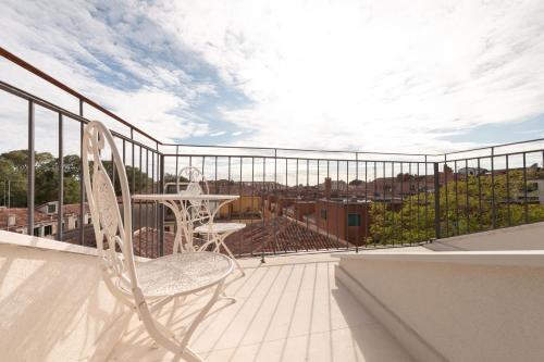 a white chair sitting on a balcony with a view at Ca' Bonfadini Historic Experience in Venice