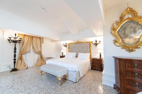 a bedroom with a white bed and a mirror at Ca' Bonfadini Historic Experience in Venice