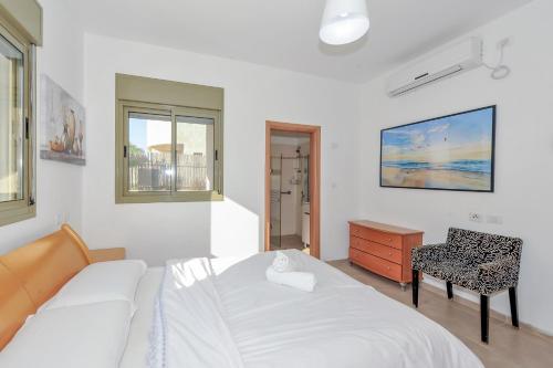 a bedroom with a bed and a desk and a chair at Family-Friendly Apartment in Zichron Yaakov in Zikhron Ya'akov