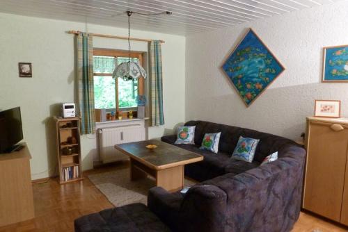 a living room with a couch and a table at Appartementhaus Osserblick in Lohberg