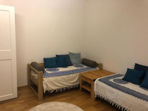 a room with two beds with blue pillows at Ferienwohnung Eiskögerl im Barbarahof in Bischofshofen