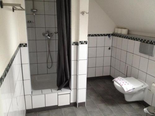 a bathroom with a shower and a toilet at Hotel Saarland Lebach in Lebach