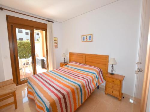 een slaapkamer met een bed met een kleurrijk gestreepte deken bij Apartamento Benvinguts I in Jávea