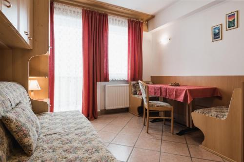 a small room with a table and a red curtain at Apparthotel Sellaronda in Arabba