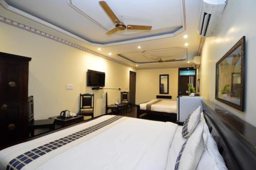 a bedroom with a bed and a ceiling fan at Hotel Surya Garh in Jaipur