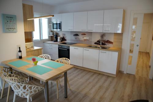 uma cozinha com armários brancos e uma mesa e cadeiras em En el corazon de Marbella em Marbella