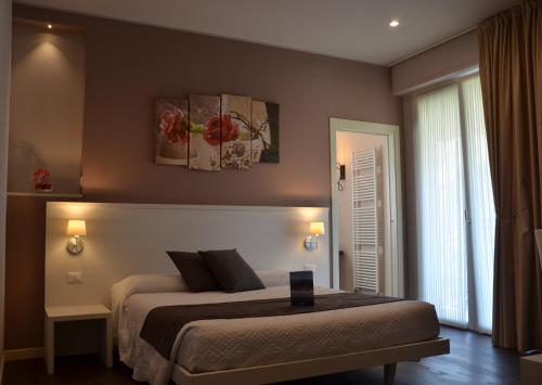 - une chambre avec un grand lit et une fenêtre dans l'établissement H2o, à Sirmione